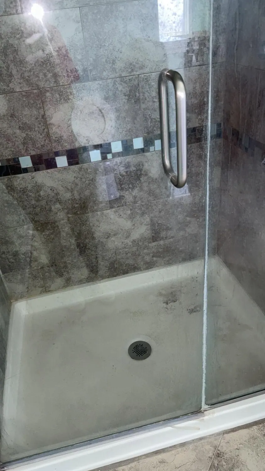 Tiled shower and glass door cleaned free of soap scum