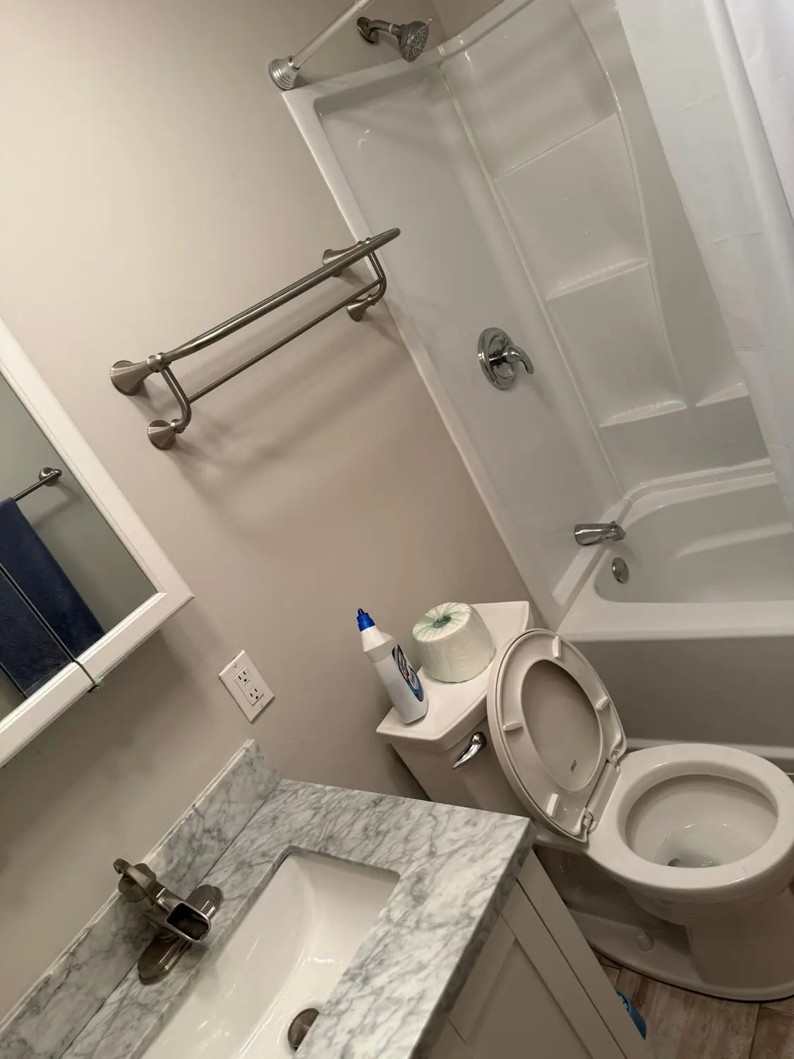 Toilet, tub, and marble vanity cleaned in a guest bath