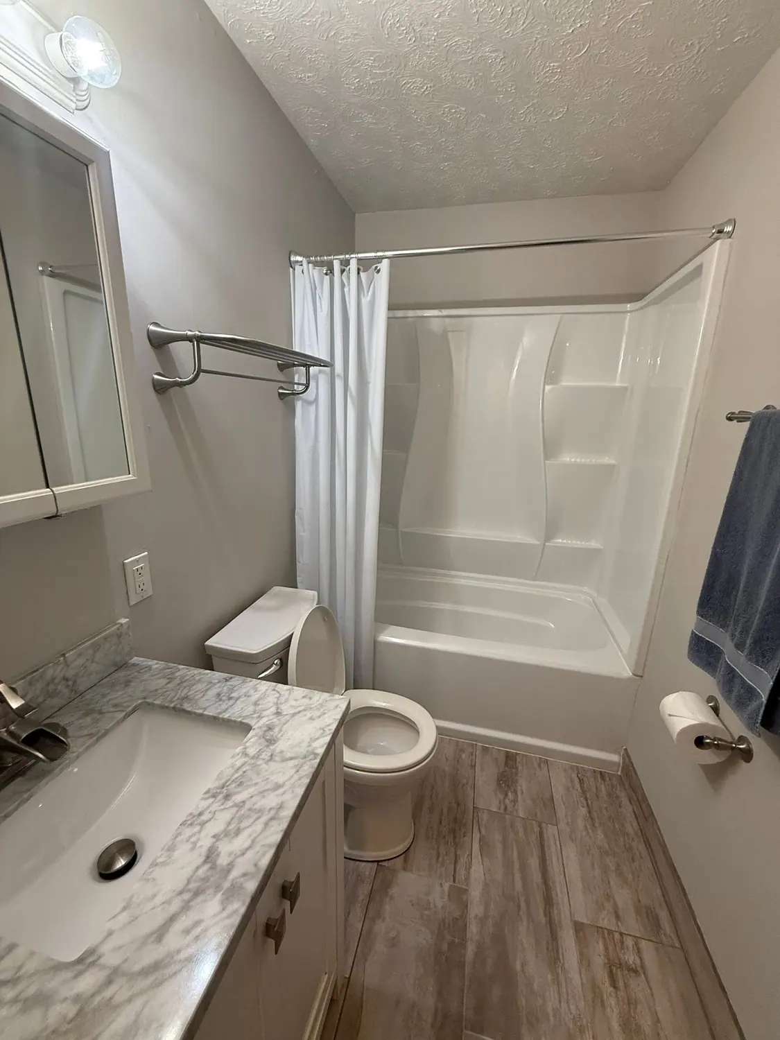 Tub, shower curtain, and marble vanity cleaned in a full bathroom