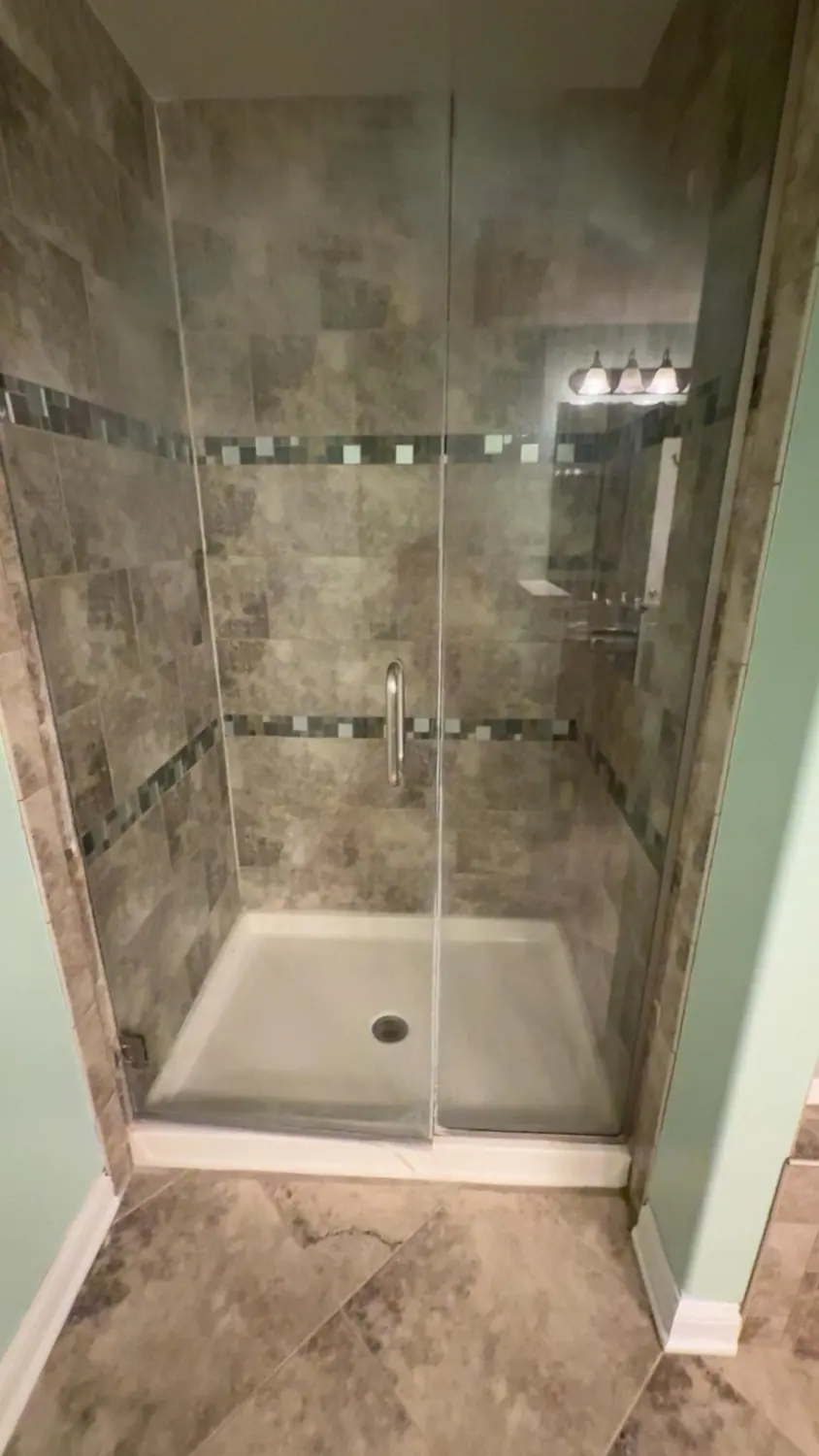 Tiled walk-in shower and glass door left spotless after a deep clean