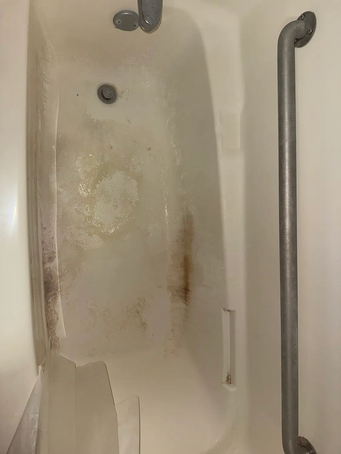 Mildew and staining on a tub surround before a deep clean