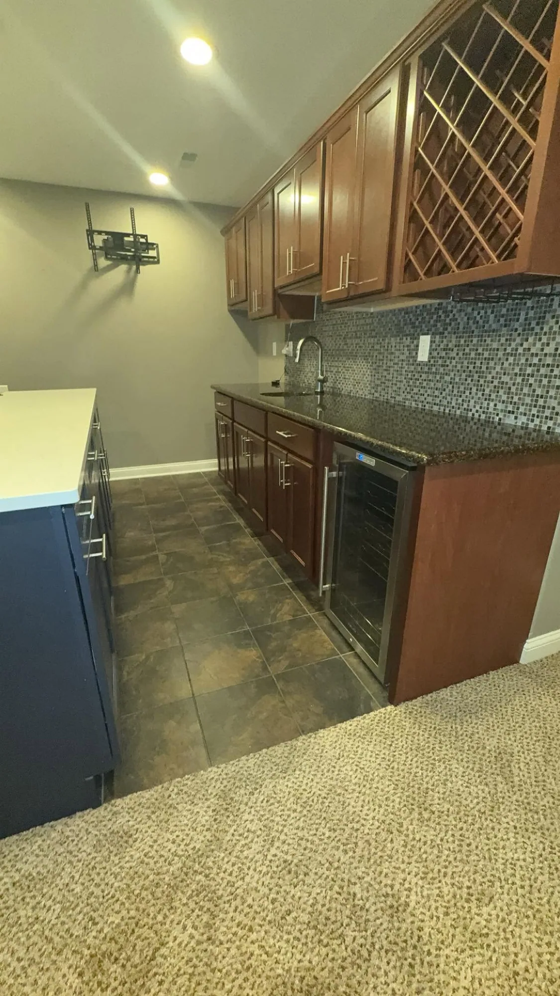 Granite bar, cabinetry, and tile floor cleaned in a home kitchen