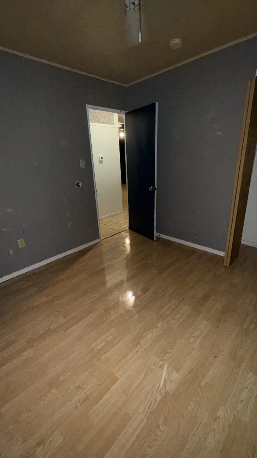 Hardwood floor and door frame cleaned in an empty room